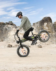 Person riding a balance OTIDA R7 MAX Dual Motor Electric Bike in a rocky outdoor setting