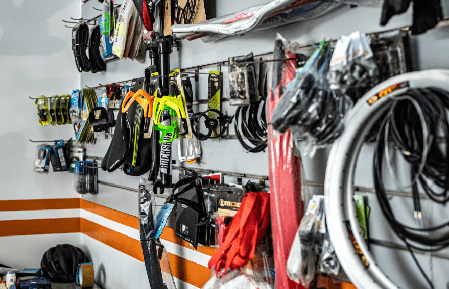 Electric bike parts and accessories displayed on wall at Pogo Cycles e-bike store.