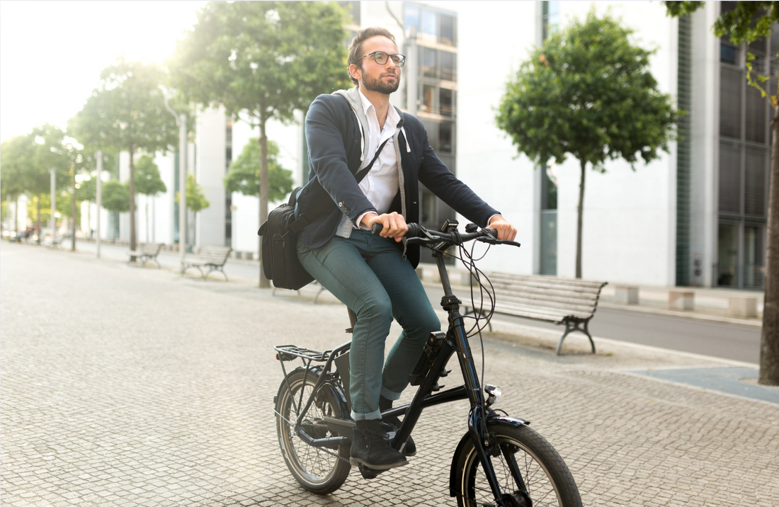 Electric bike side view with commuter in business attire riding on city street