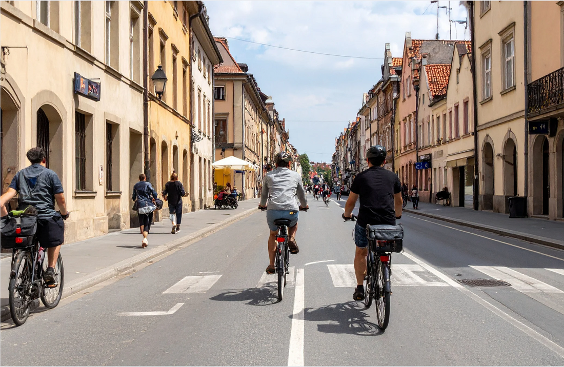 Cyclists riding electric bikes through a city street, promoting Pogo Cycles urban e bikes.