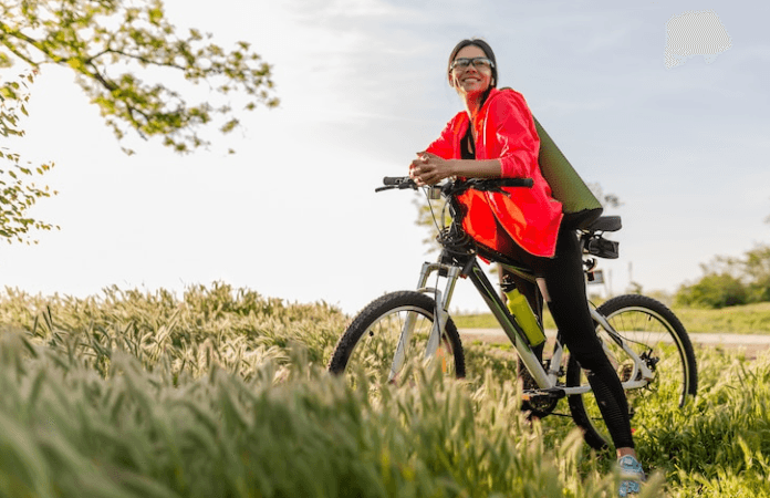 Woman riding electric bike outdoors in green field, Pogo Cycles e-bike lifestyle
